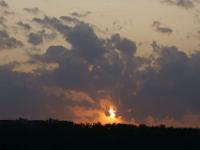 Sonnenball zwischen Wolken und Wald am Wolga Moskau Kanal